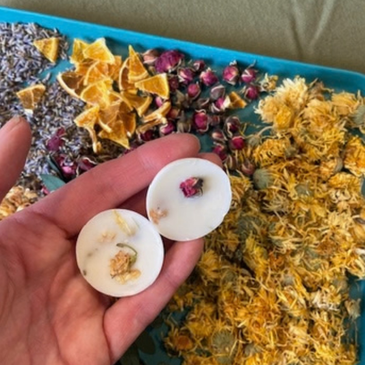 Soy Wax Melt Workshop Nottingham with white round wax melts decorated with dried rosebuds and yellow botanicals